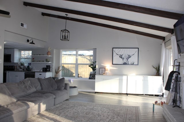 living room with hardwood / wood-style flooring, sink, high vaulted ceiling, and beam ceiling