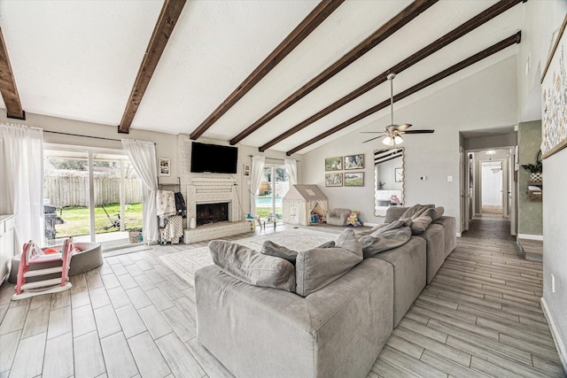 living room featuring plenty of natural light, a fireplace, and beam ceiling