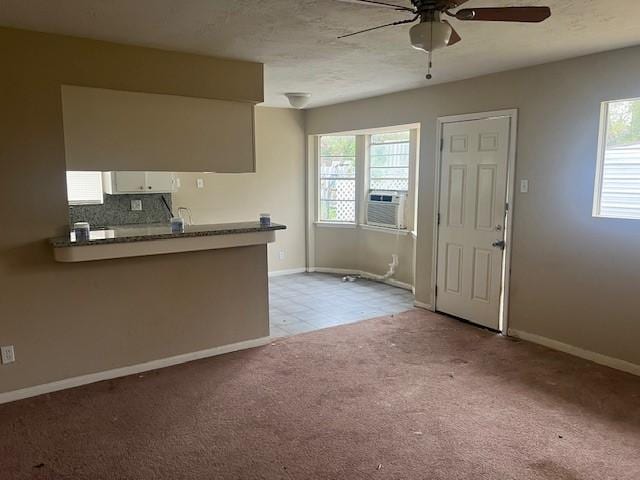 kitchen with ceiling fan, cooling unit, white cabinets, light carpet, and decorative backsplash