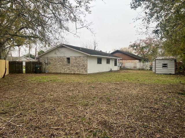 rear view of house with a yard and a shed