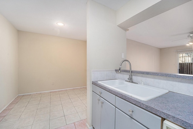 kitchen featuring ceiling fan, sink, and light tile patterned flooring