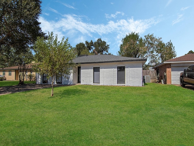 exterior space with central air condition unit and a yard