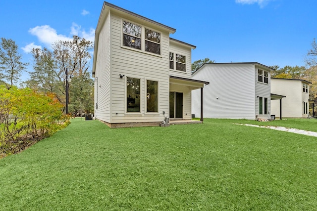 rear view of property featuring central AC unit and a yard