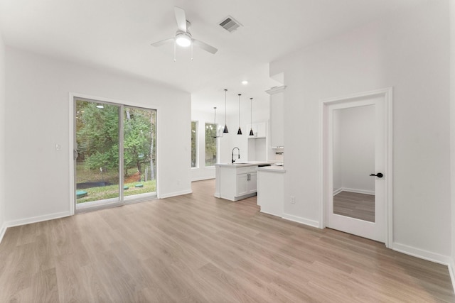 unfurnished living room featuring ceiling fan, sink, and light hardwood / wood-style flooring