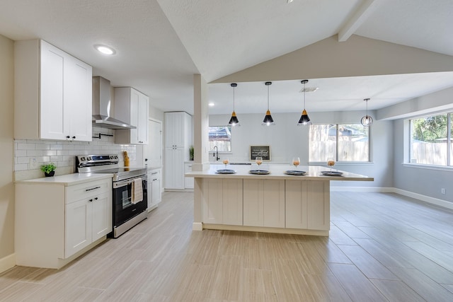 kitchen with pendant lighting, white cabinets, wall chimney exhaust hood, vaulted ceiling with beams, and electric stove