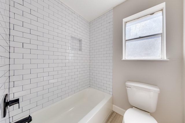 bathroom with toilet, tiled shower / bath combo, and hardwood / wood-style floors