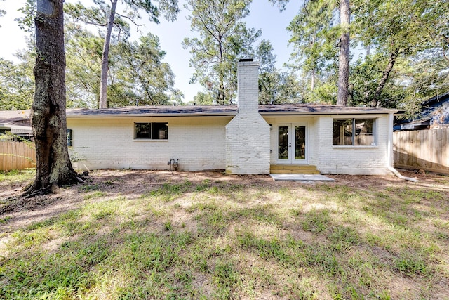 back of property with french doors and a yard