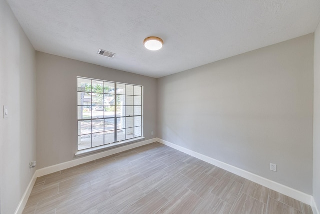 unfurnished room with a textured ceiling