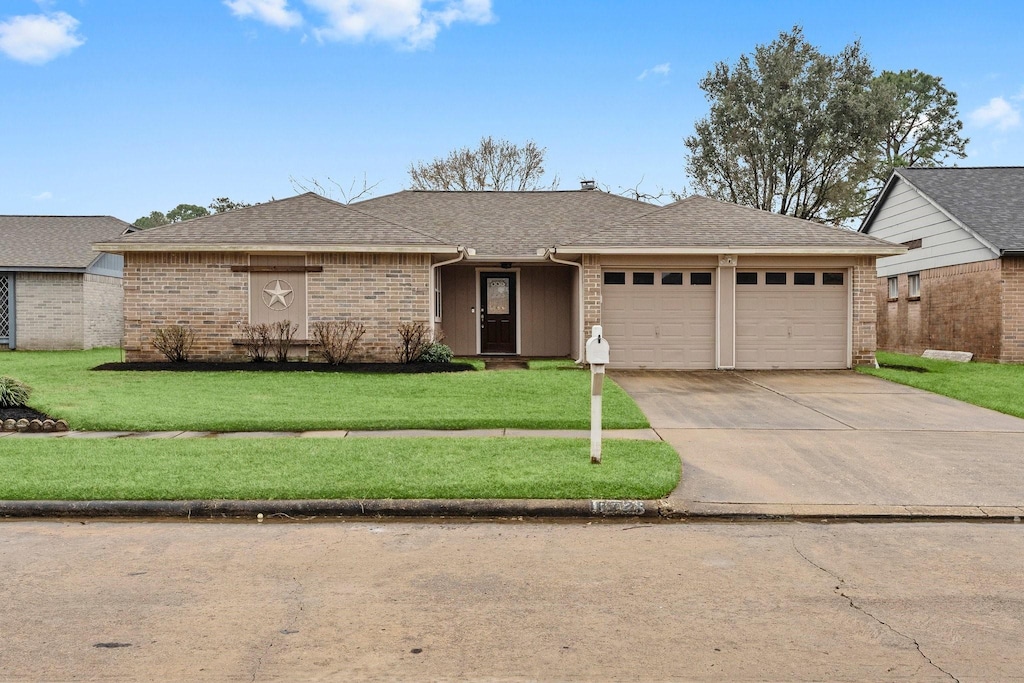 ranch-style house with a garage and a front yard