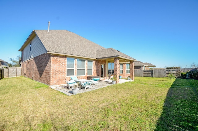 back of property with a patio area and a lawn