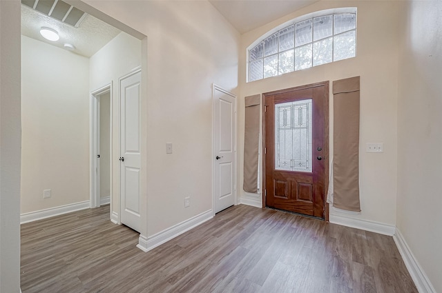 foyer entrance with light hardwood / wood-style flooring and a textured ceiling