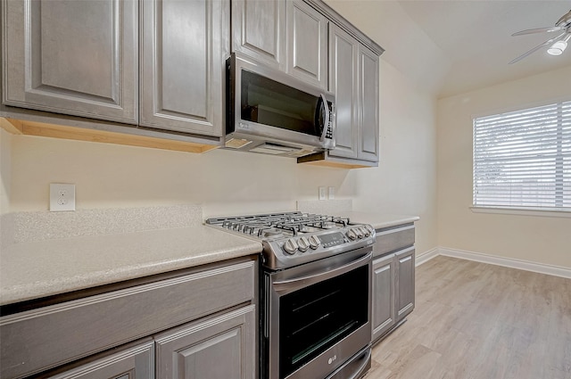 kitchen with stainless steel appliances, gray cabinetry, ceiling fan, and light hardwood / wood-style flooring