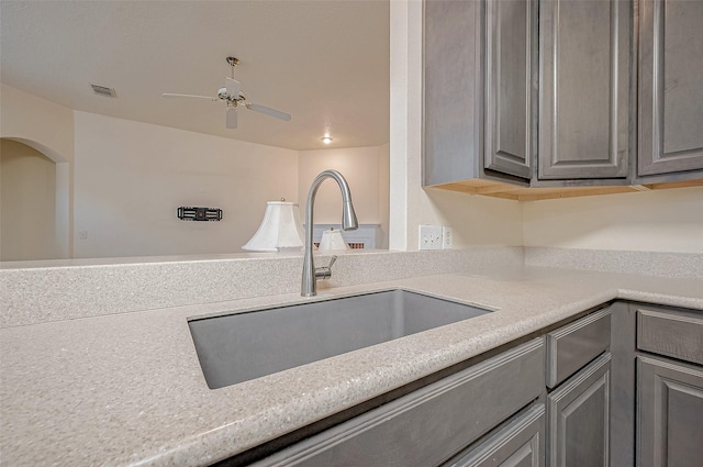 kitchen with ceiling fan, sink, and gray cabinetry