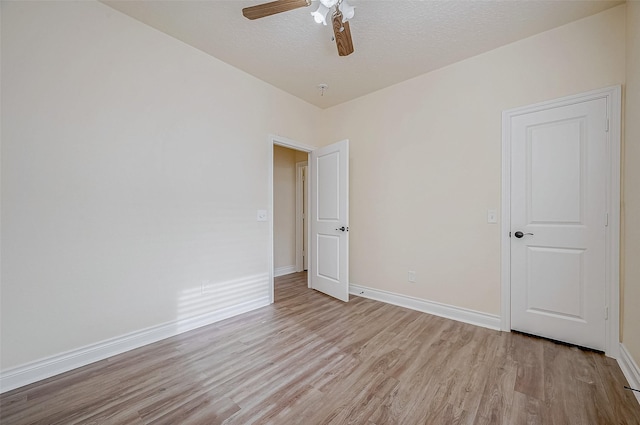 empty room with a textured ceiling, light hardwood / wood-style flooring, and ceiling fan