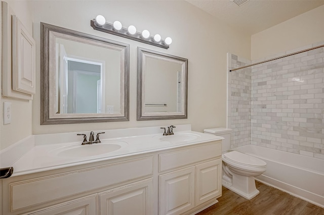 full bathroom with toilet, a textured ceiling, vanity, tiled shower / bath combo, and hardwood / wood-style flooring