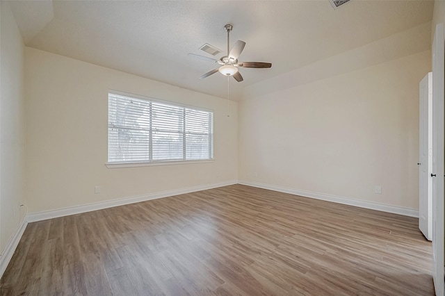 empty room featuring ceiling fan, lofted ceiling, and light hardwood / wood-style floors