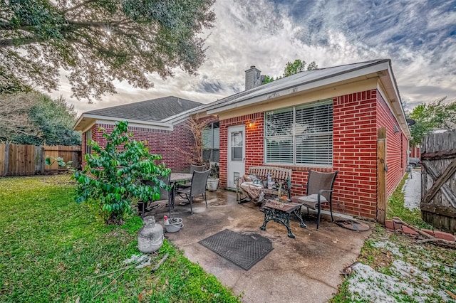 back of house with a yard and a patio