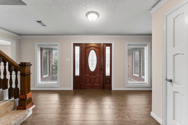 foyer entrance featuring crown molding, dark wood-type flooring, and a textured ceiling