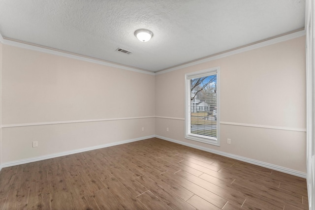 spare room featuring dark hardwood / wood-style flooring, crown molding, and a textured ceiling