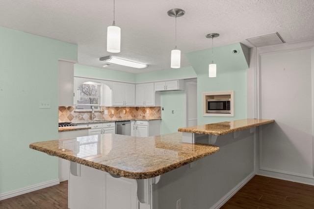 kitchen with a breakfast bar, white cabinets, and decorative light fixtures