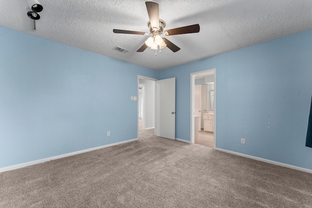 unfurnished bedroom with ceiling fan, ensuite bathroom, carpet floors, and a textured ceiling