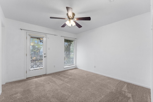 spare room with ceiling fan and light colored carpet