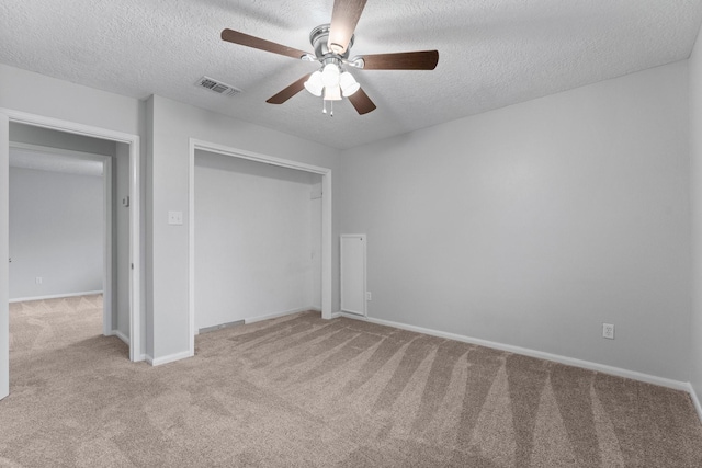 unfurnished bedroom with light carpet, a textured ceiling, and a closet