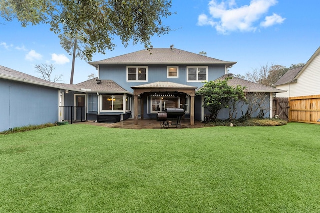 rear view of house featuring a yard and a gazebo