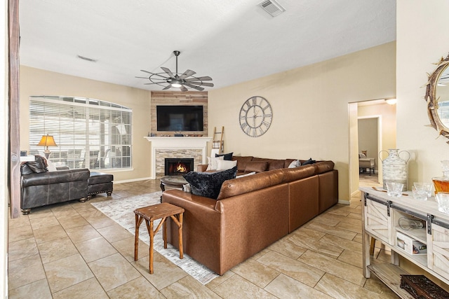 living room with ceiling fan and a fireplace