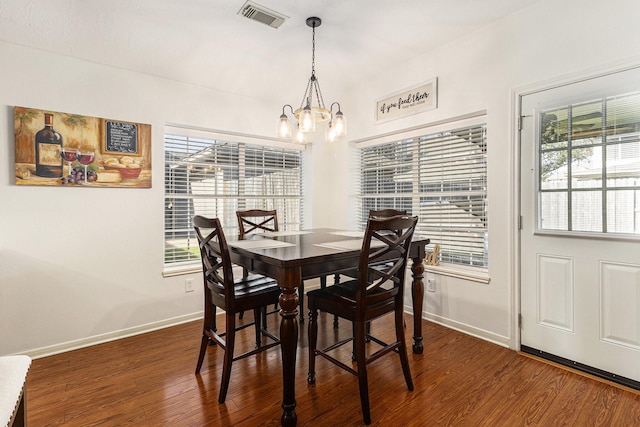 dining space featuring a wealth of natural light, an inviting chandelier, and dark wood-type flooring