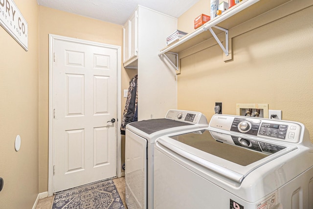 clothes washing area featuring cabinets and separate washer and dryer