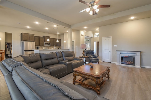 living room featuring light hardwood / wood-style flooring and ceiling fan