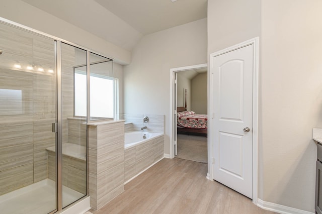 bathroom featuring independent shower and bath, vanity, lofted ceiling, and hardwood / wood-style floors