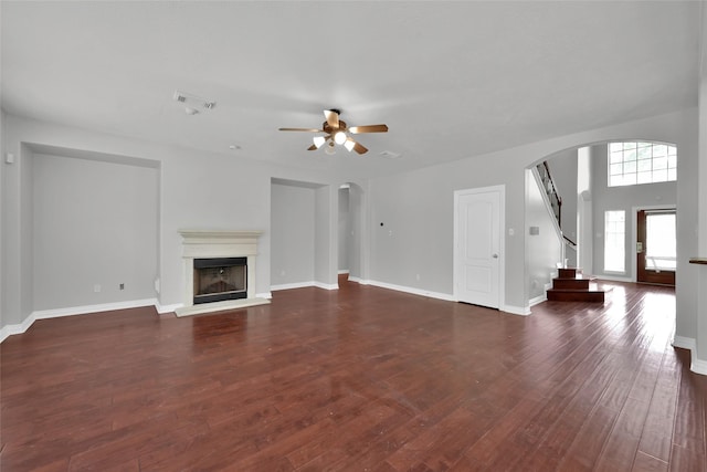 unfurnished living room featuring ceiling fan and dark hardwood / wood-style flooring