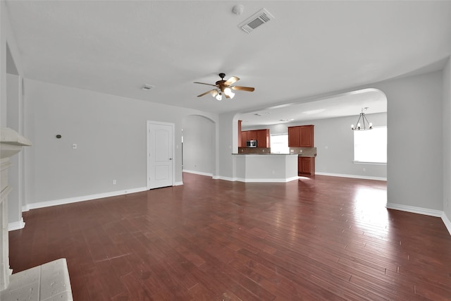 unfurnished living room featuring dark hardwood / wood-style flooring and ceiling fan with notable chandelier