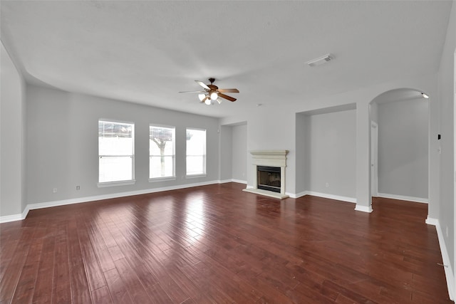 unfurnished living room featuring ceiling fan and dark wood-type flooring