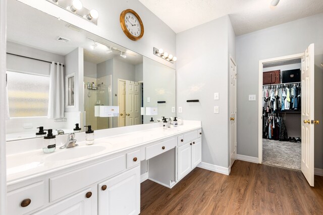 bathroom featuring hardwood / wood-style flooring, a textured ceiling, vanity, and a shower with door