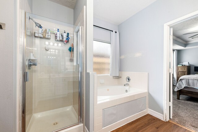 bathroom with ornamental molding, hardwood / wood-style floors, a textured ceiling, and shower with separate bathtub