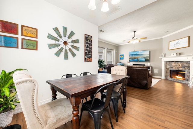 dining area with a fireplace, hardwood / wood-style floors, and ornamental molding