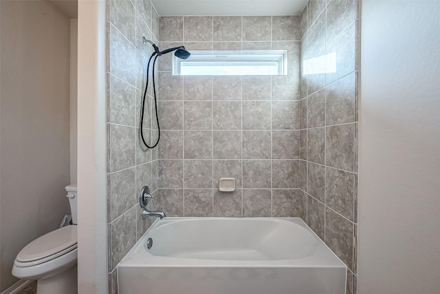 bathroom featuring tiled shower / bath and toilet