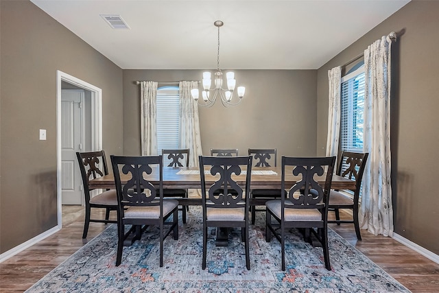 dining area featuring a notable chandelier and wood-type flooring