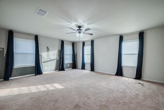 carpeted spare room featuring ceiling fan