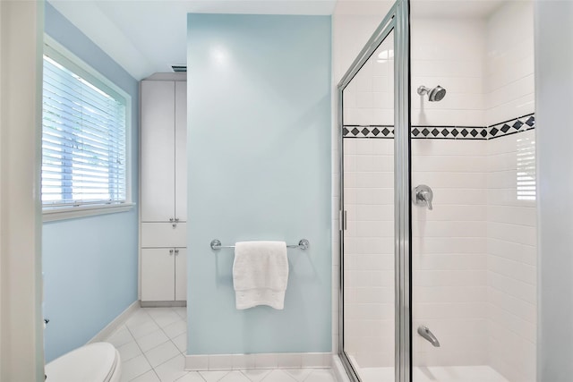 bathroom featuring toilet, tile patterned flooring, and a shower with door