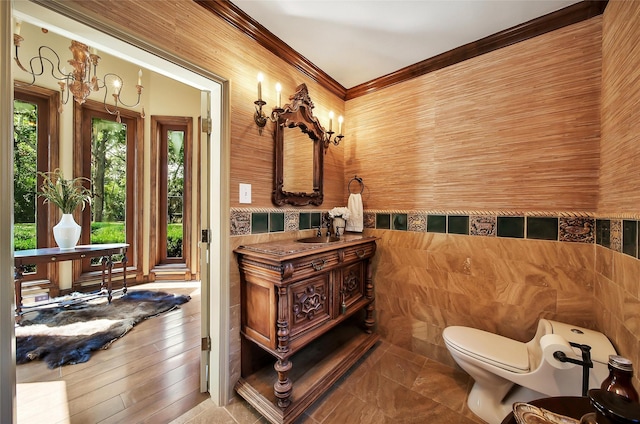 bathroom with toilet, ornamental molding, and vanity