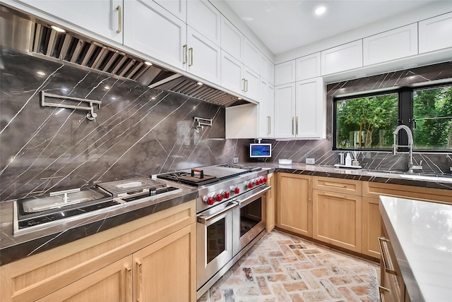 kitchen with white cabinets, double oven range, backsplash, and sink