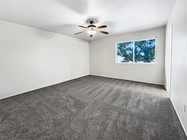 spare room featuring ceiling fan and dark colored carpet