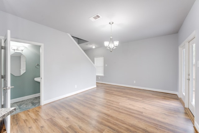 interior space featuring a wealth of natural light, light hardwood / wood-style flooring, and an inviting chandelier