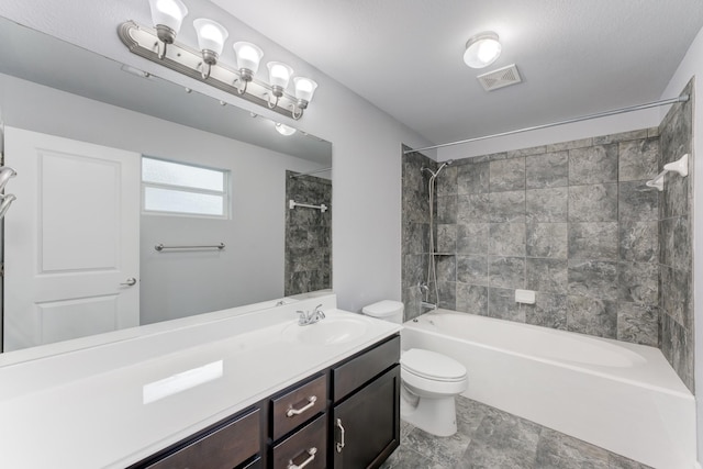 full bathroom featuring toilet, tiled shower / bath, and vanity