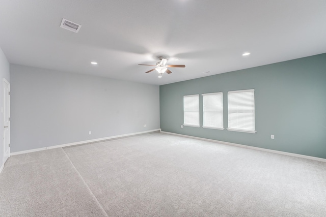 carpeted spare room featuring ceiling fan