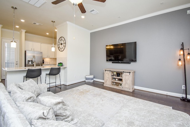 living room featuring dark wood-type flooring and crown molding